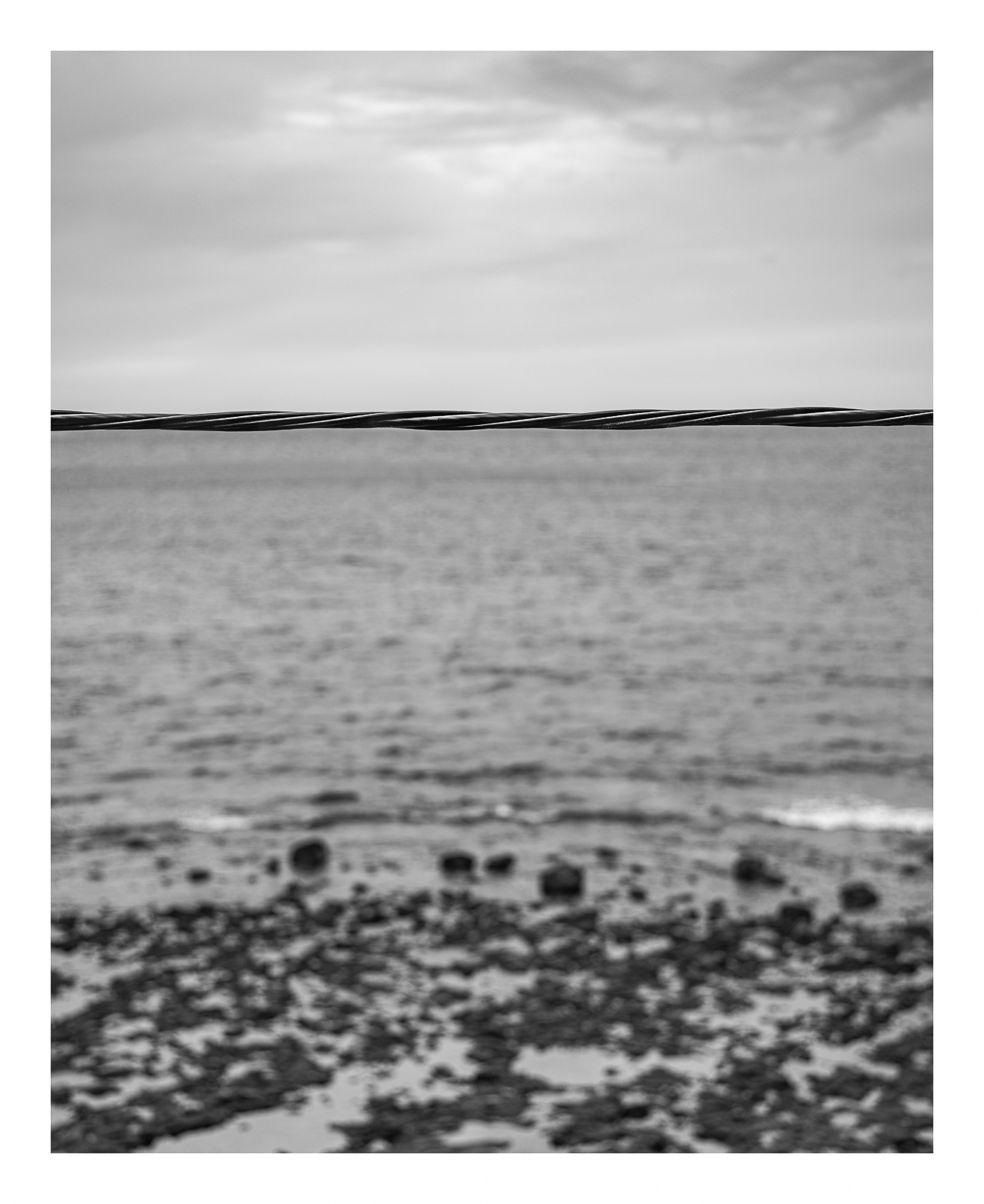 fotografo-mar-rocas-cielo-cable-acero-blanco-negro.jpg