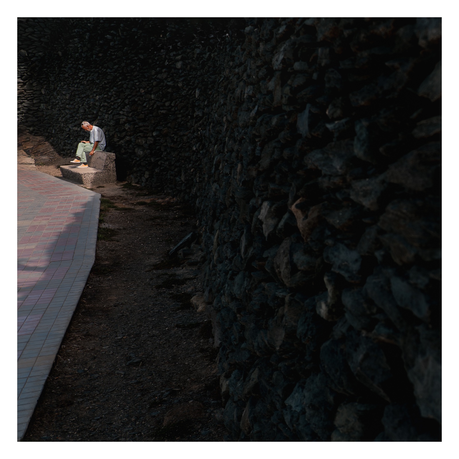 fotografo-persona-hombre-sentado-banco-muro-piedra.jpg