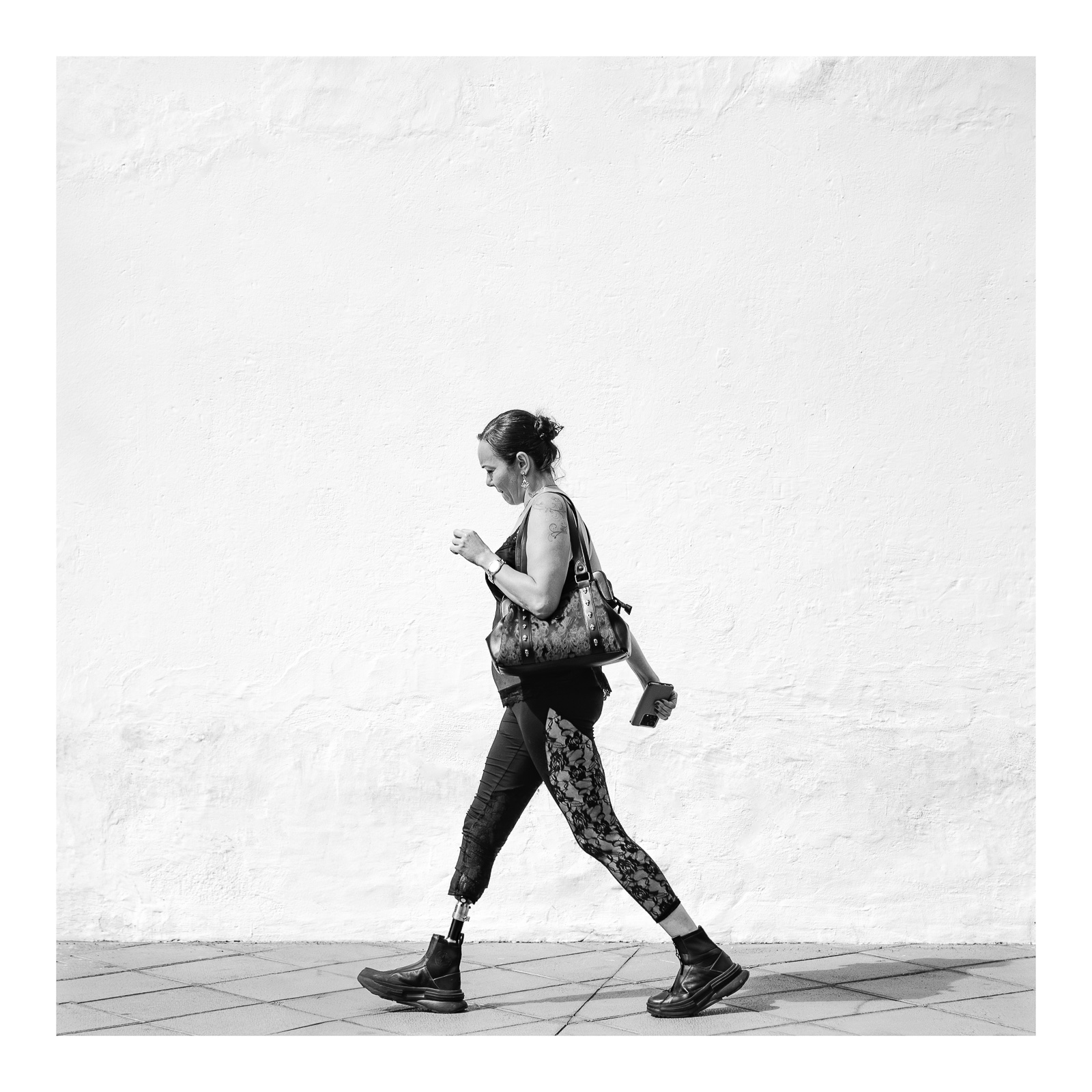 fotografo-persona-mujer-ropa-negra-movil-bolso-reloj-pierna-ortopedica.jpg