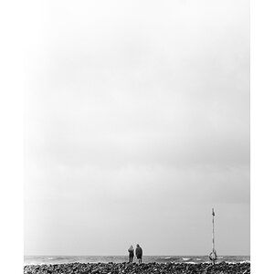 fotografo-mar-piedras-salvavidas-poste-personas-hombre-mujer-capucha-blanco-negro.jpg