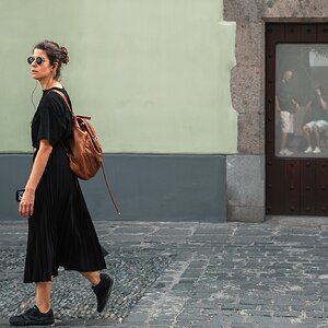 fotografo-calle-persona-chica-bolso-marron-porton-madera-reflejo-cristal-opaco-adoquin.jpg