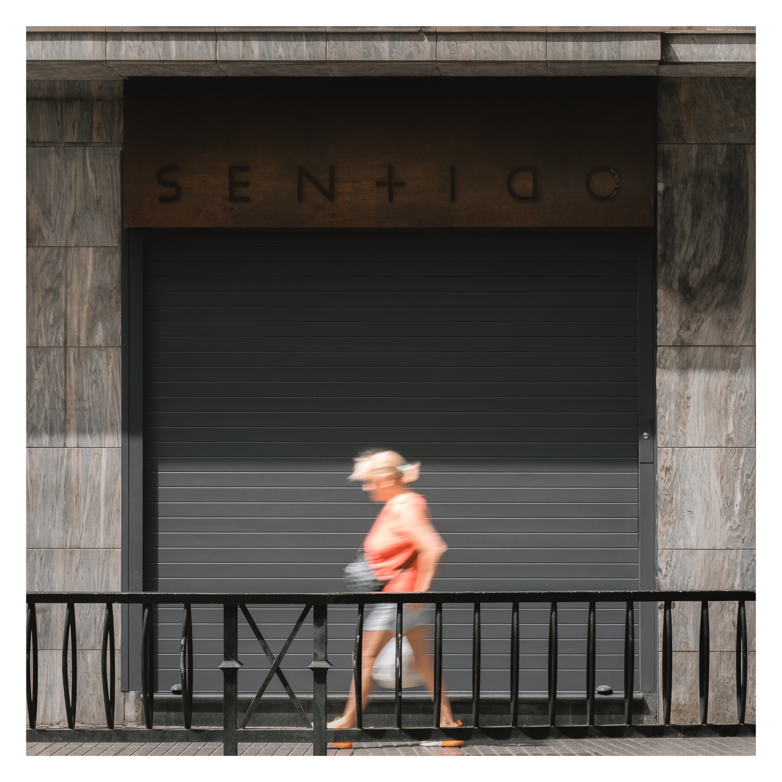 fotografo-callejear-persona-mujer-puerta-metalica-señal-vial-barandilla.jpg